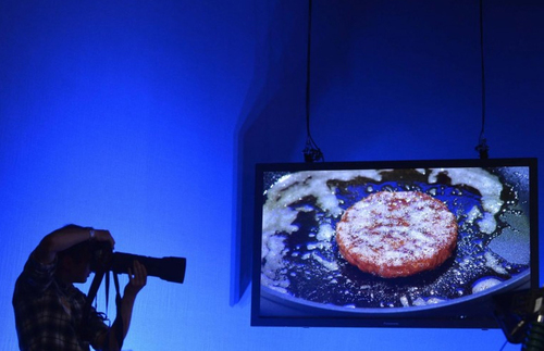 A photographer shoots in a television studio with a live screen view behind as the worlds first lab-grown beef burger is cooked during a launch event in west London, August 5, 2013. (Toby Melville/Reuters)